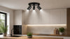 Modern kitchen with white cabinets, wooden countertops, and a black faucet. Black ceiling spotlight and under-cabinet lighting create a cozy ambiance. Plants add freshness.