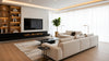 A modern living room featuring white furniture, a cozy fireplace, and contemporary decor elements.
